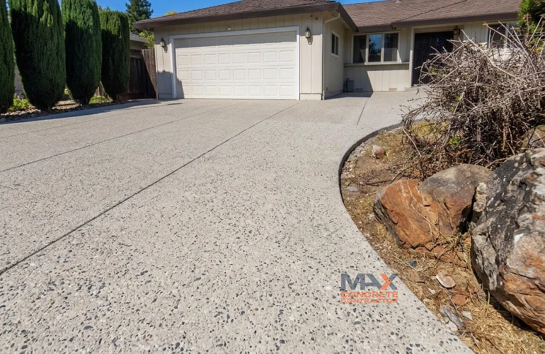 Exposed aggregate concrete driveway with curved landscape edge in Mission Viejo, CA