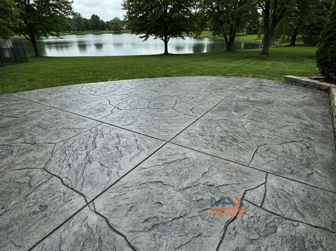 Workers stamping a textured pattern into freshly poured concrete on a driveway in Irvine, CA