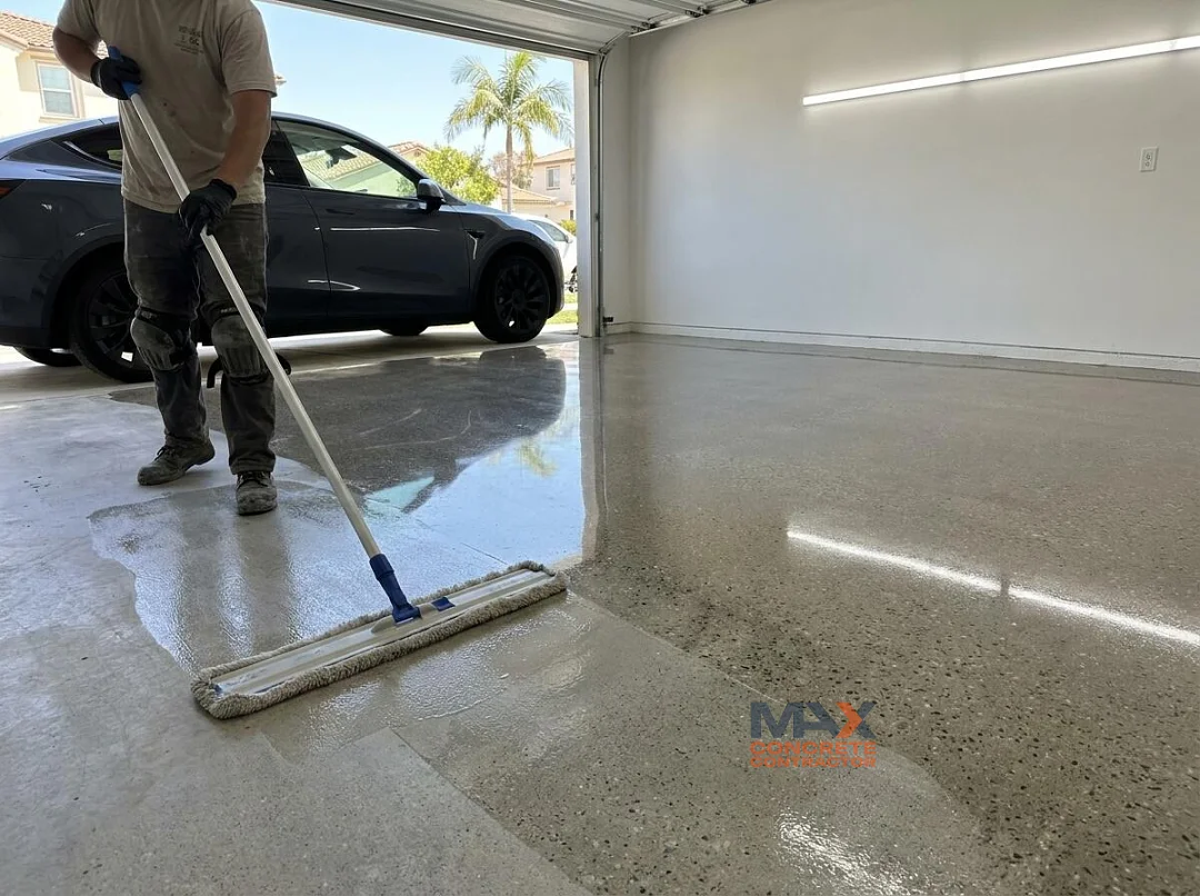 Worker applying densifier to a high-gloss polished concrete floor with exposed aggregate in Irvine, CA