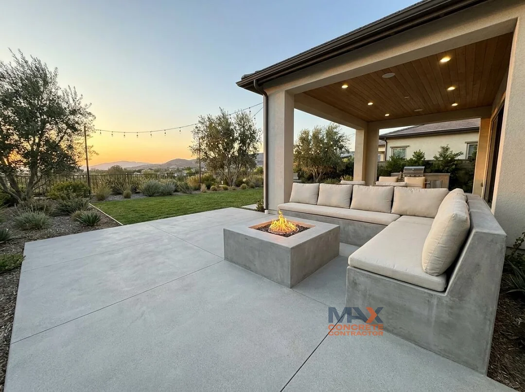 Built-in concrete fire pit lounge on a backyard patio at dusk in Irvine, CA